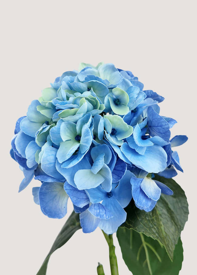 Close-up of blue artificial hydrangea flower with realistic petal detail