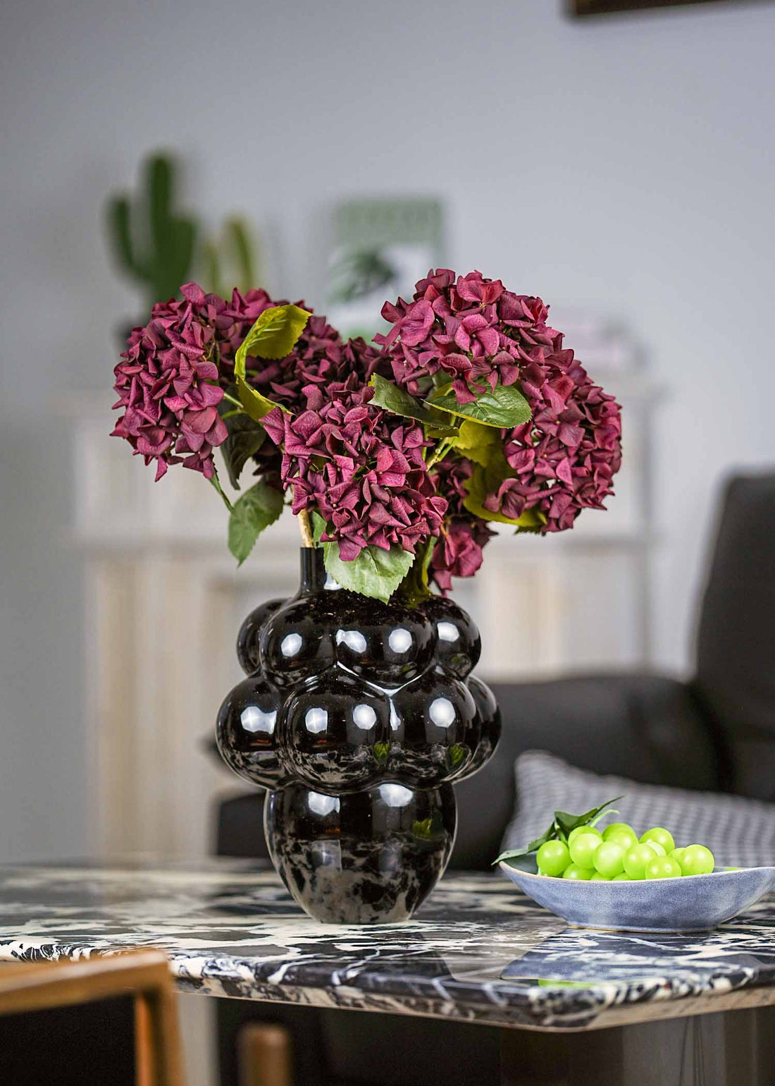 Crimson velvet artificial hydrangea bouquet in black sculptural vase for elegant home decor.