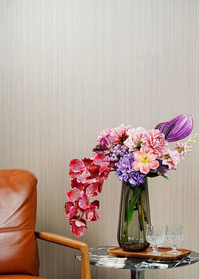 Elegant burgundy rose and orchid artificial flower arrangement styled in a modern living room with glass vase – Everblooma luxury faux floral décor