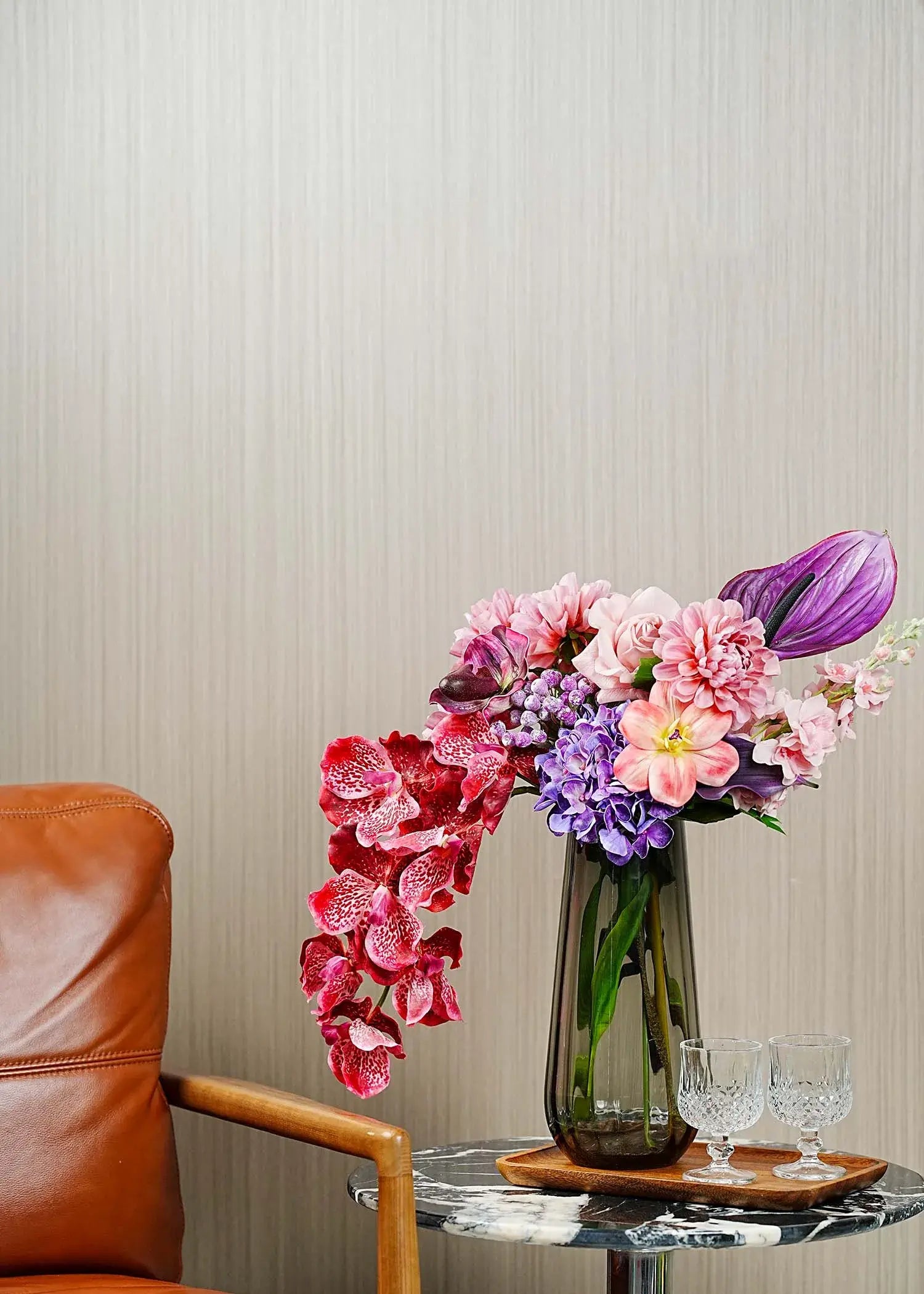 Elegant burgundy rose and orchid artificial flower arrangement styled in a modern living room with glass vase – Everblooma luxury faux floral décor