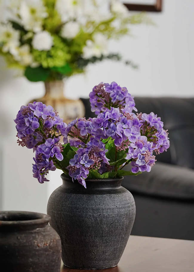 Purple artificial hydrangea flower arrangement in dark ceramic vase on wooden table, elegant home decor by Everblooma