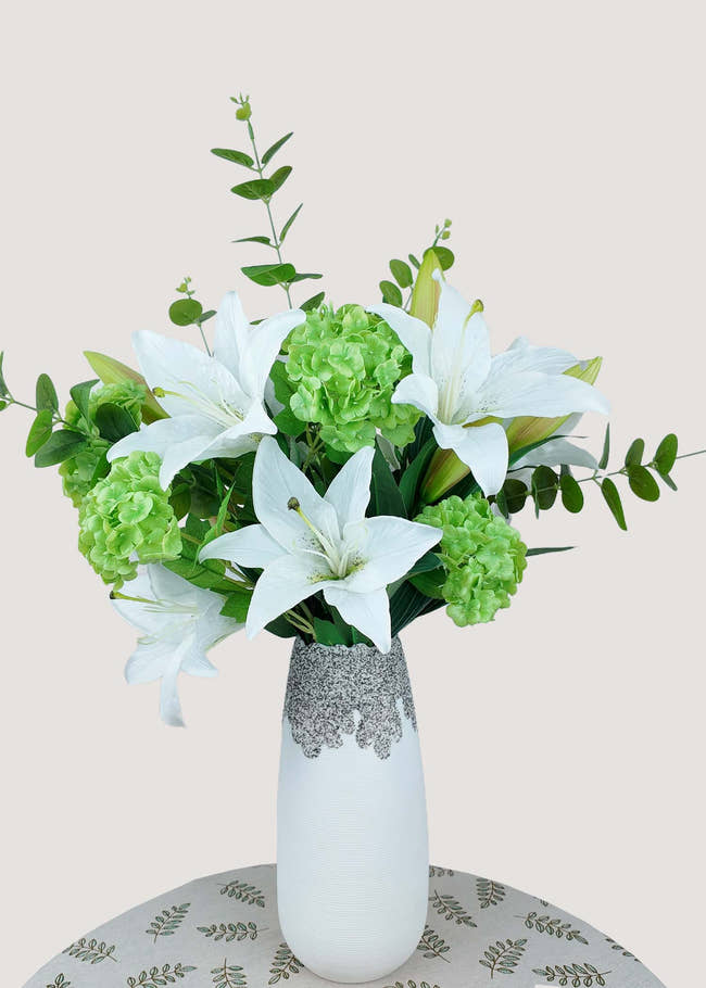 Elegant white faux lilies and green hydrangeas in vase – luxury artificial floral arrangement