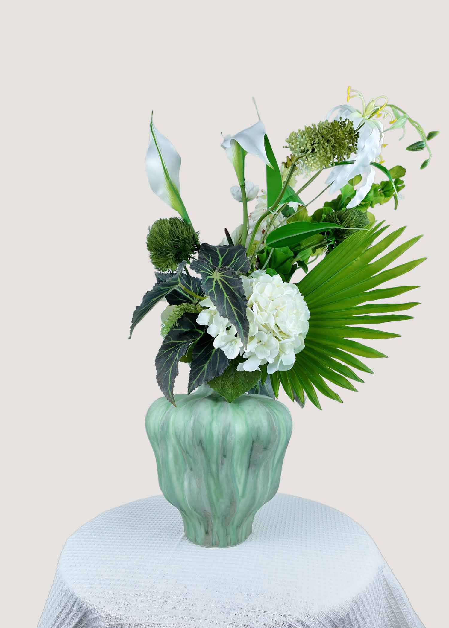 Close-up details of faux white blossoms and mixed greenery
