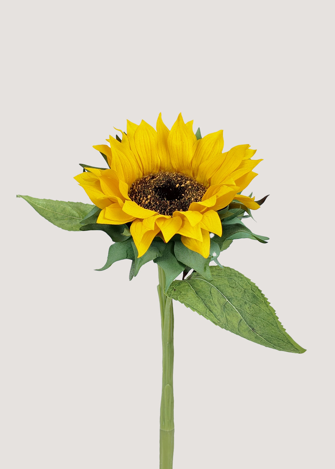 Yellow artificial sunflower stem with realistic petals and leaves