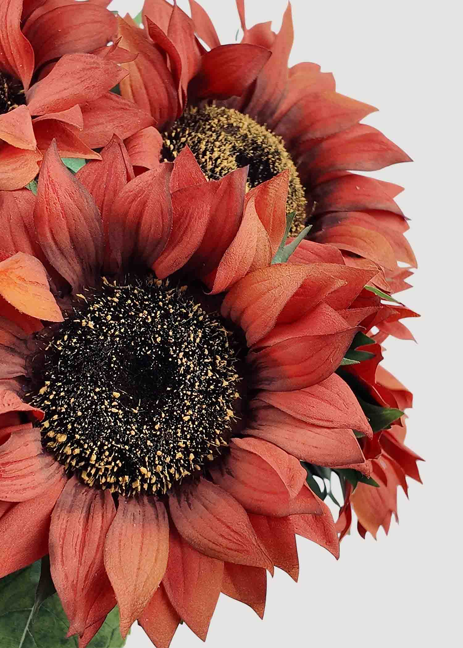 Closeup of lifelike burnt orange artificial sunflower blooms