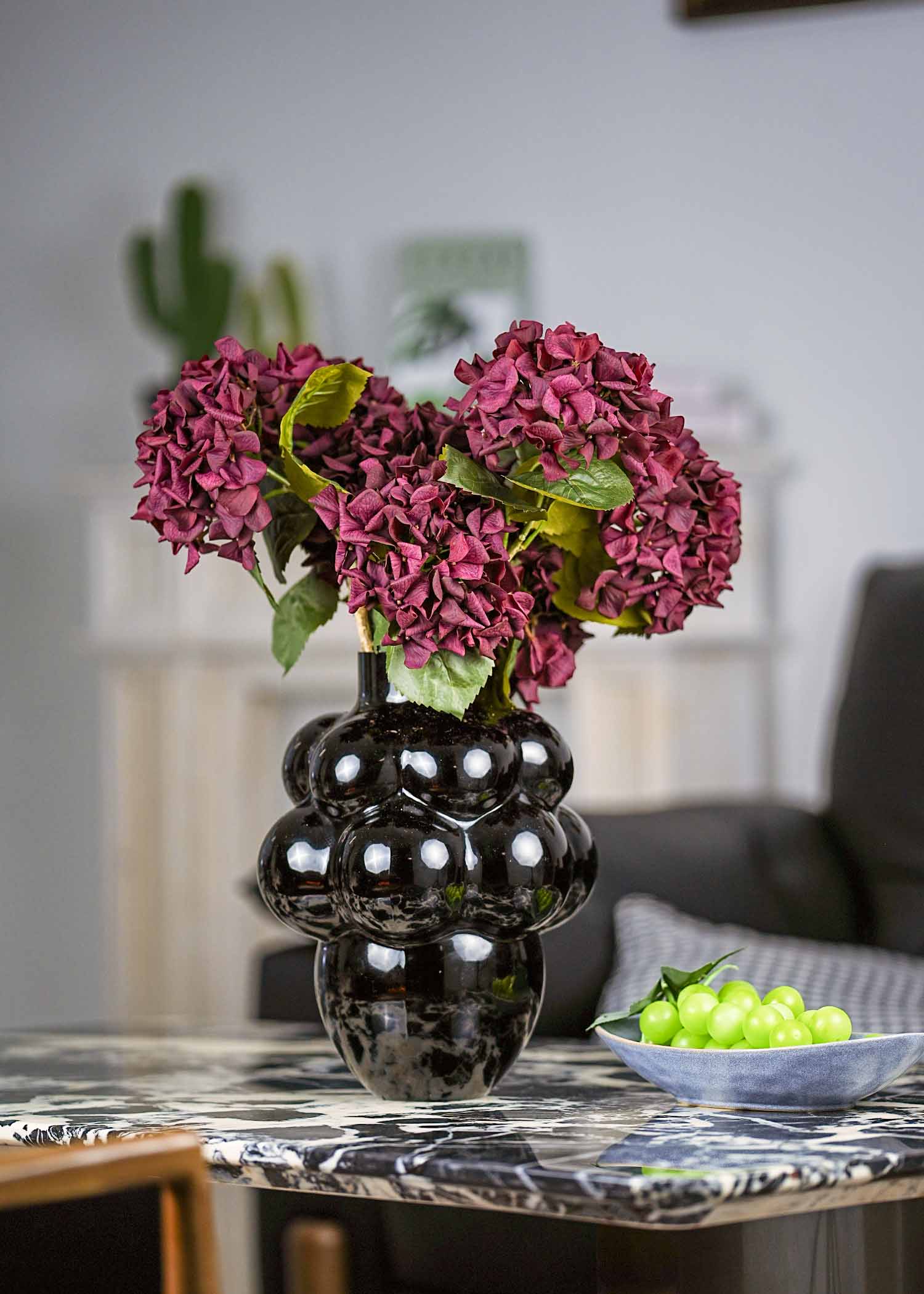 Crimson velvet artificial hydrangea bouquet in black sculptural vase for elegant home decor.