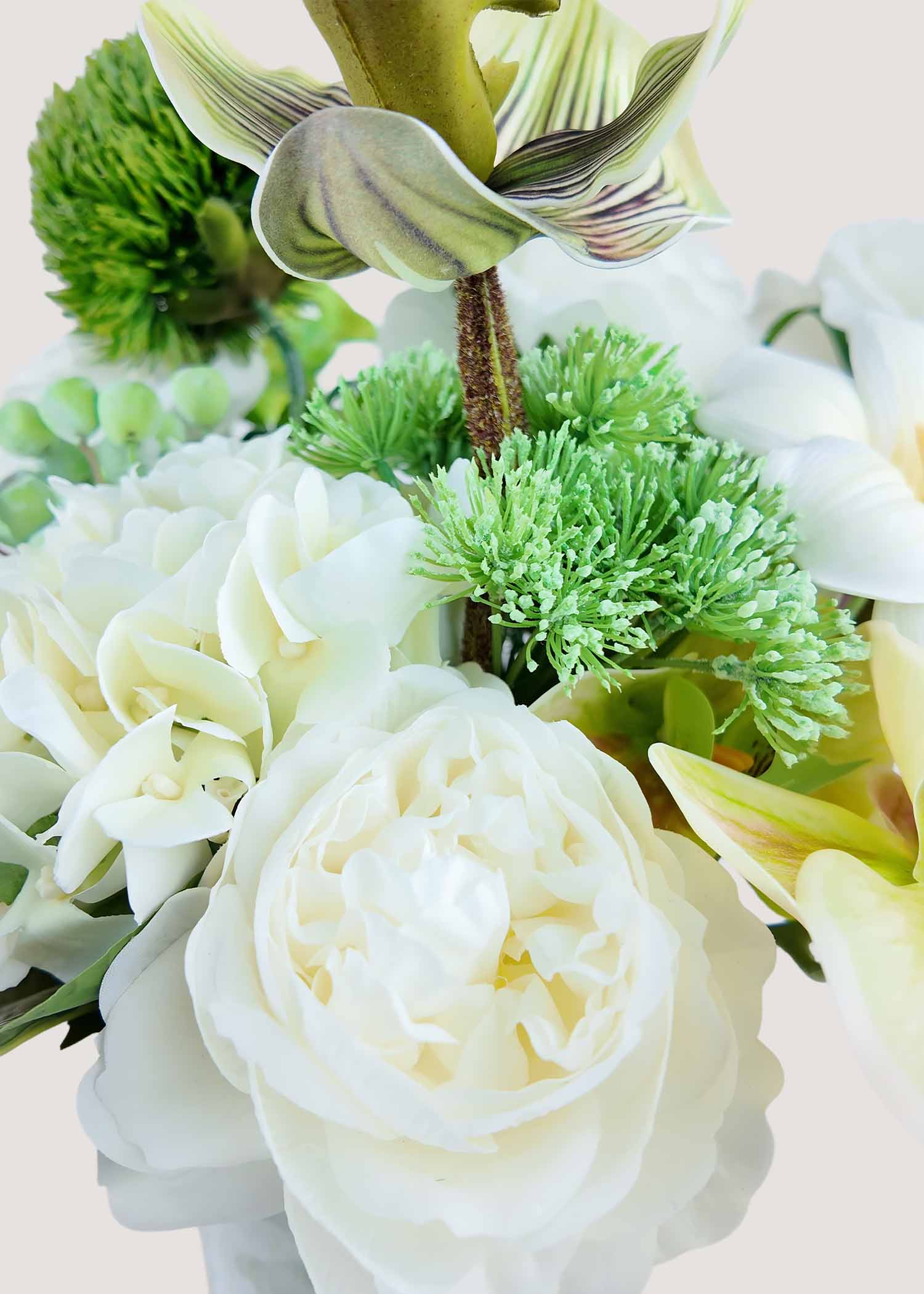 Close-up detail of deluxe white and green faux floral arrangement featuring artificial roses, orchids, and textured greenery