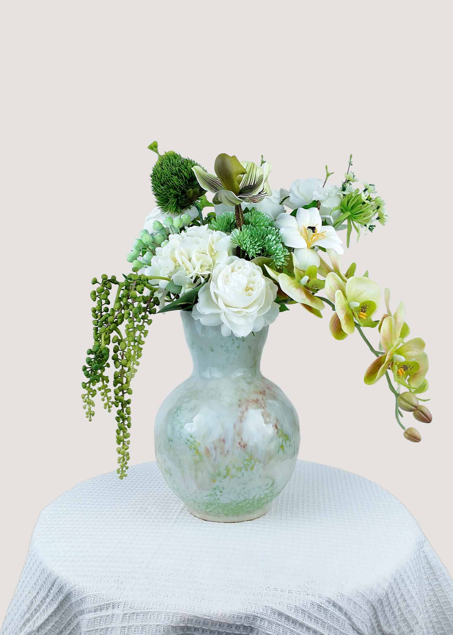 Deluxe white and green faux floral arrangement with orchids and roses in ceramic vase