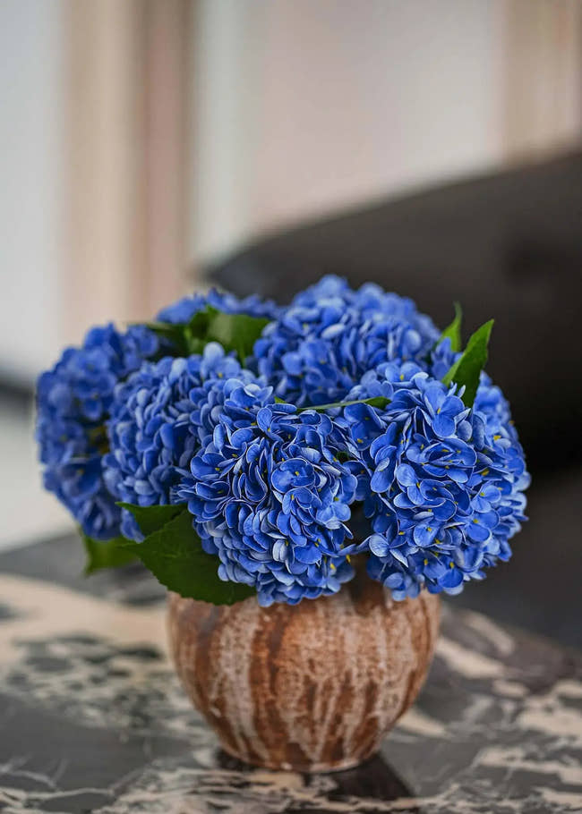 Blue artificial hydrangea flower arrangement in rustic ceramic vase on marble table, elegant home decor by Everblooma