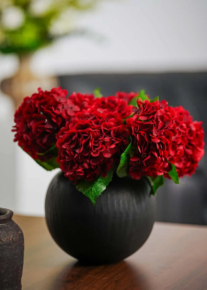 Elegant faux hydrangea arrangement in deep red tones, adding romantic warmth and sophistication to modern interior décor