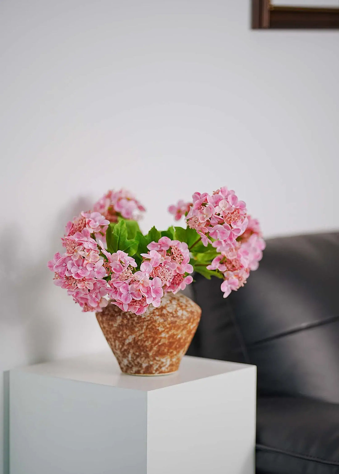 Soft pink faux hydrangeas in a rustic ceramic vase, romantic artificial flower arrangement for modern interior styling