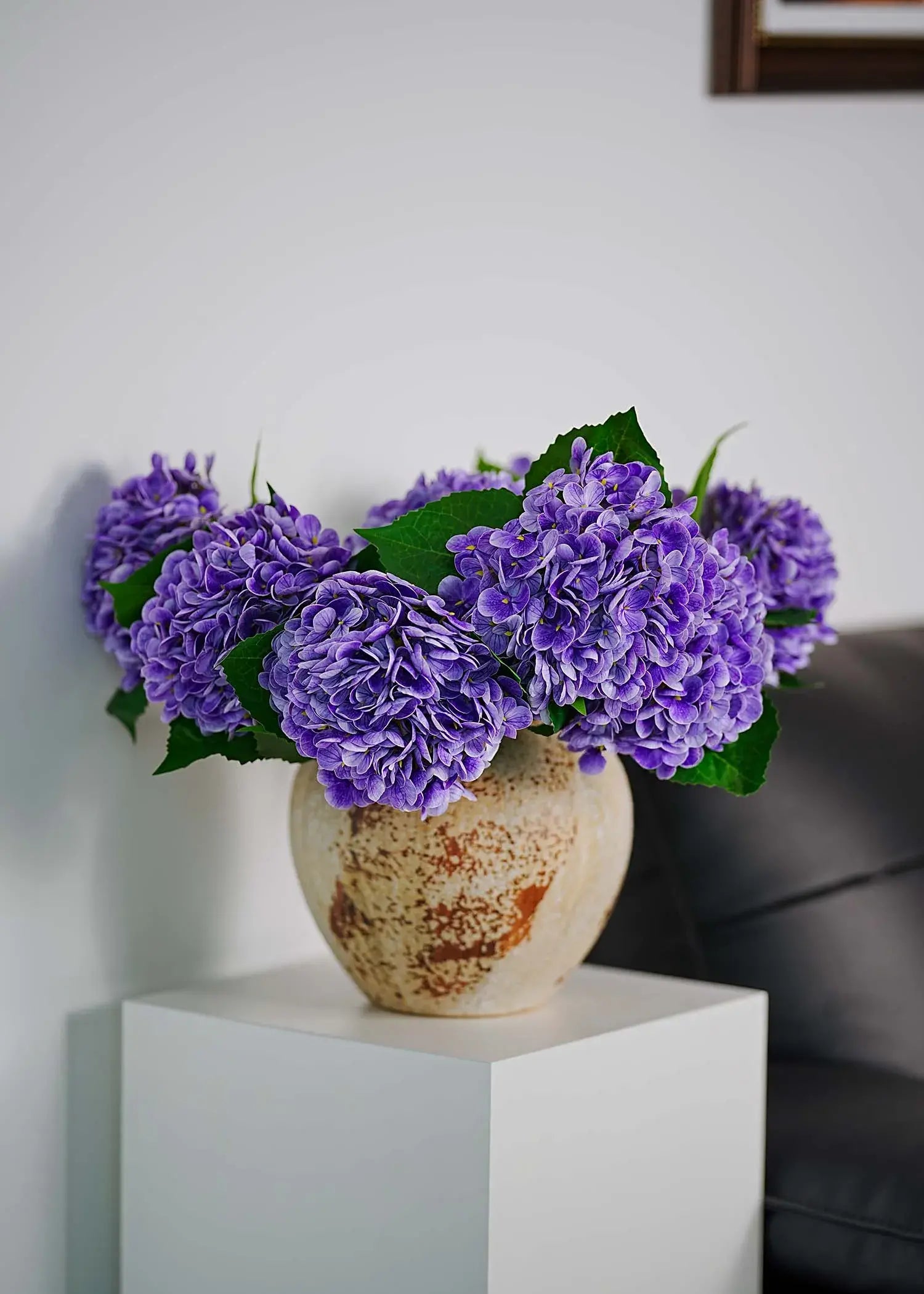 Elegant lavender faux hydrangea arrangement in ceramic vase, adding romantic color and soft texture to interior decoration