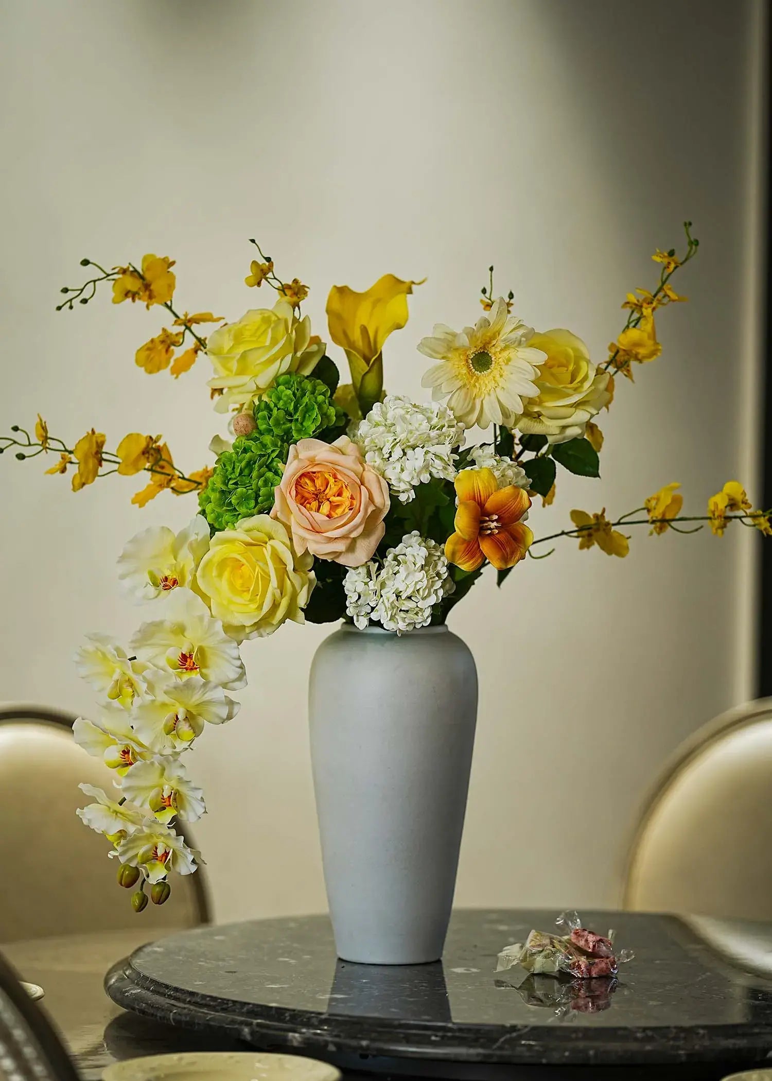 Real Touch faux floral centerpiece with roses and orchids arranged in a tall white vase on a marble dining table — Everblooma elegant home décor.