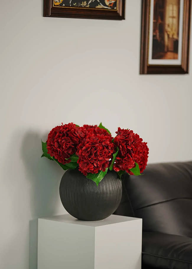 Close-up of silk deep red hydrangea blooms showcasing realistic texture and vibrant color, perfect artificial flower arrangement for living spaces