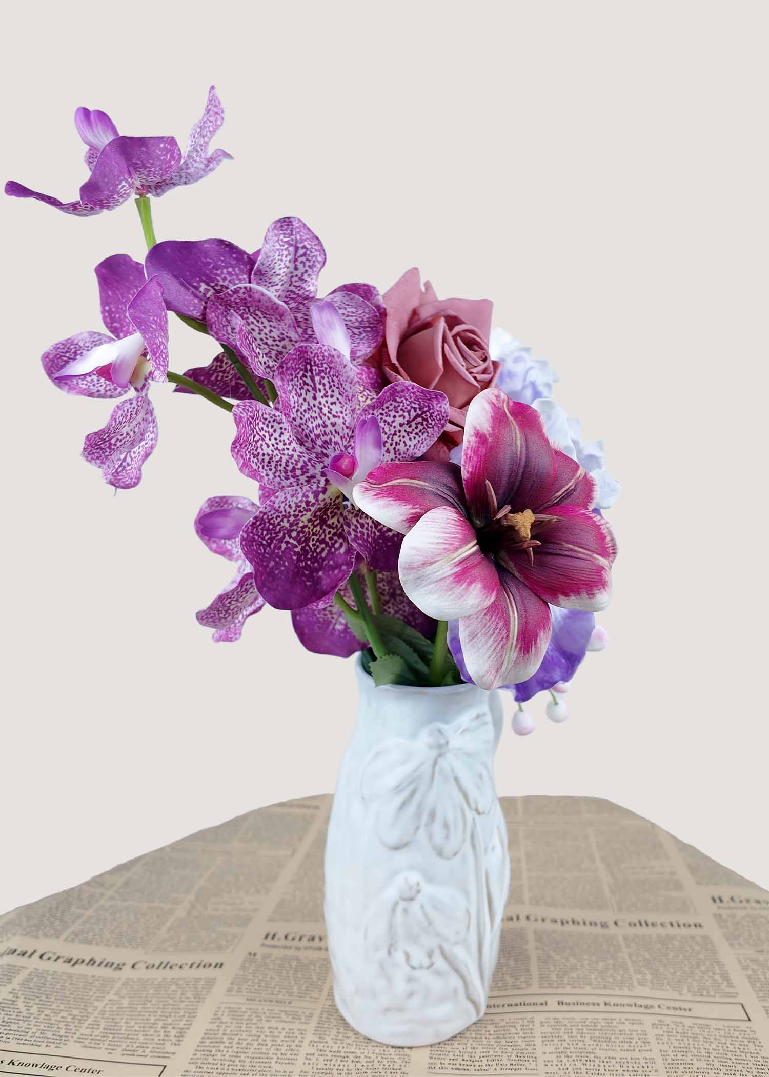 Side view of small faux mauve rose, orchid, and iris arrangement with berries.