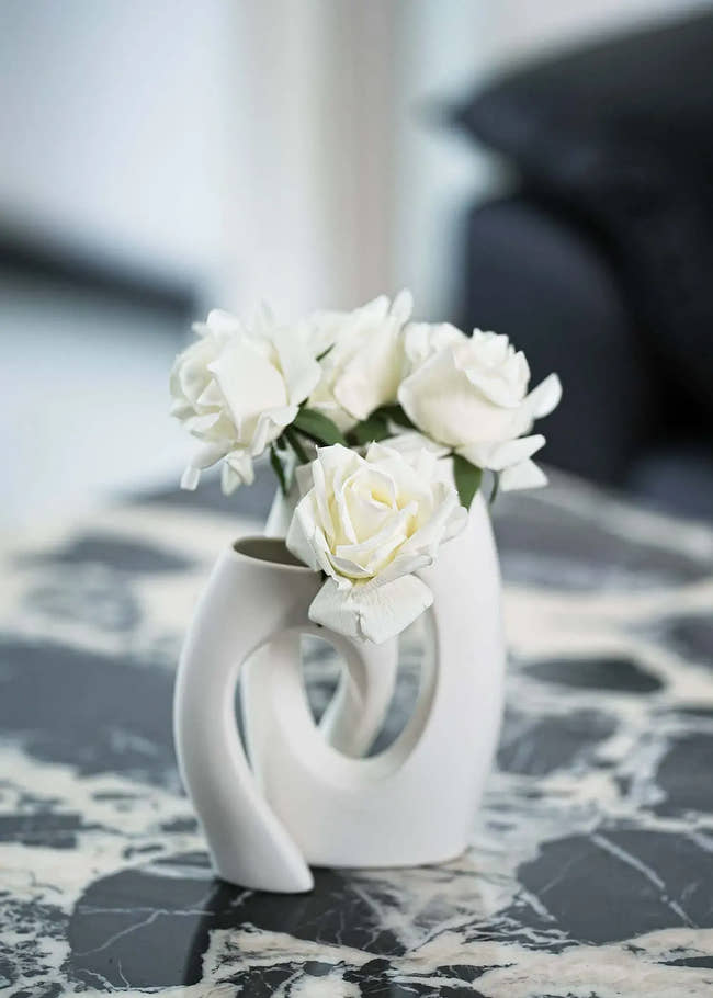 White artificial rose bouquet in modern sculptural ceramic vase on marble table, elegant home decor by Everblooma
