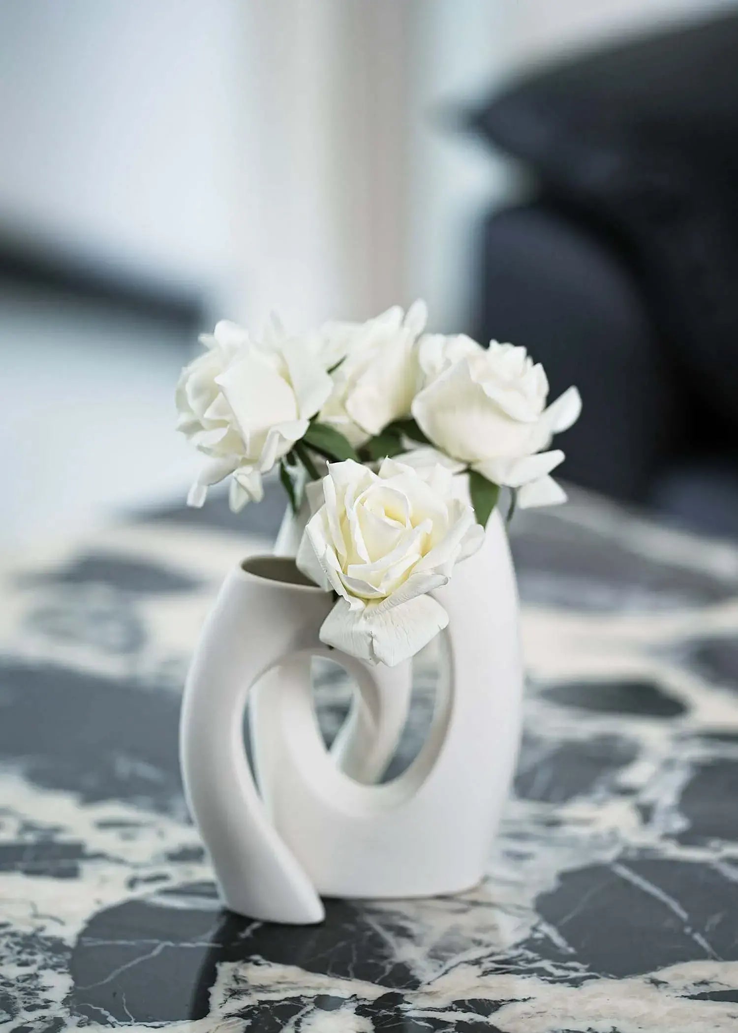 White artificial rose bouquet in modern sculptural ceramic vase on marble table, elegant home decor by Everblooma