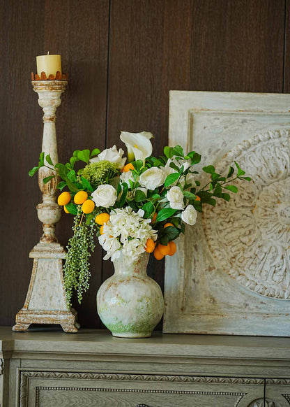 Fresh Citrus &amp; White Rose faux floral arrangement with calla lilies, hydrangea and citrus accents in a ceramic vintage vase on a classic sideboard.