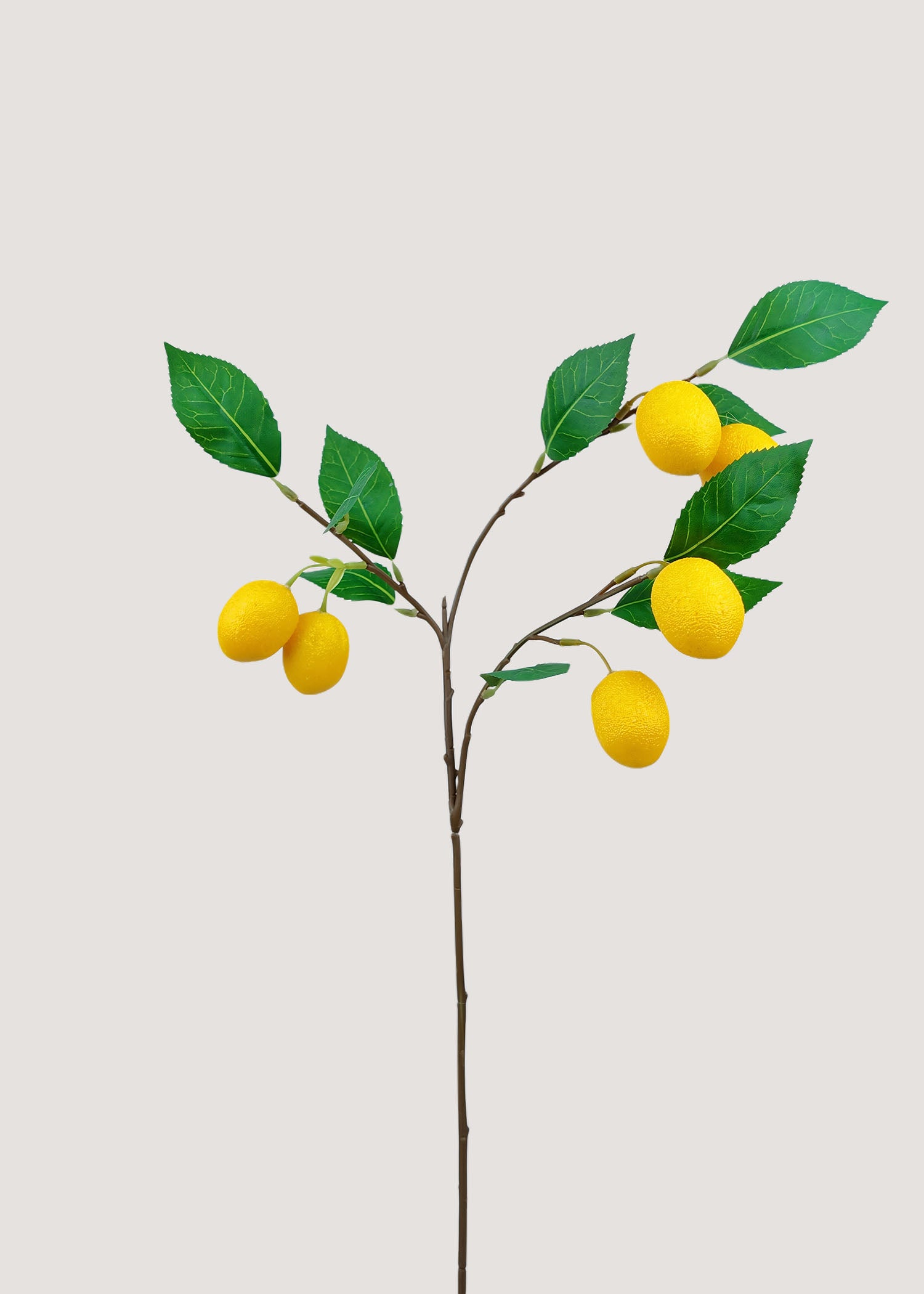 Artificial lemon branch with bright yellow fruit and green leaves