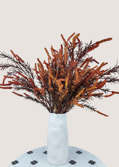 Autumn orange artificial flower bouquet with rustic faux branches in vase