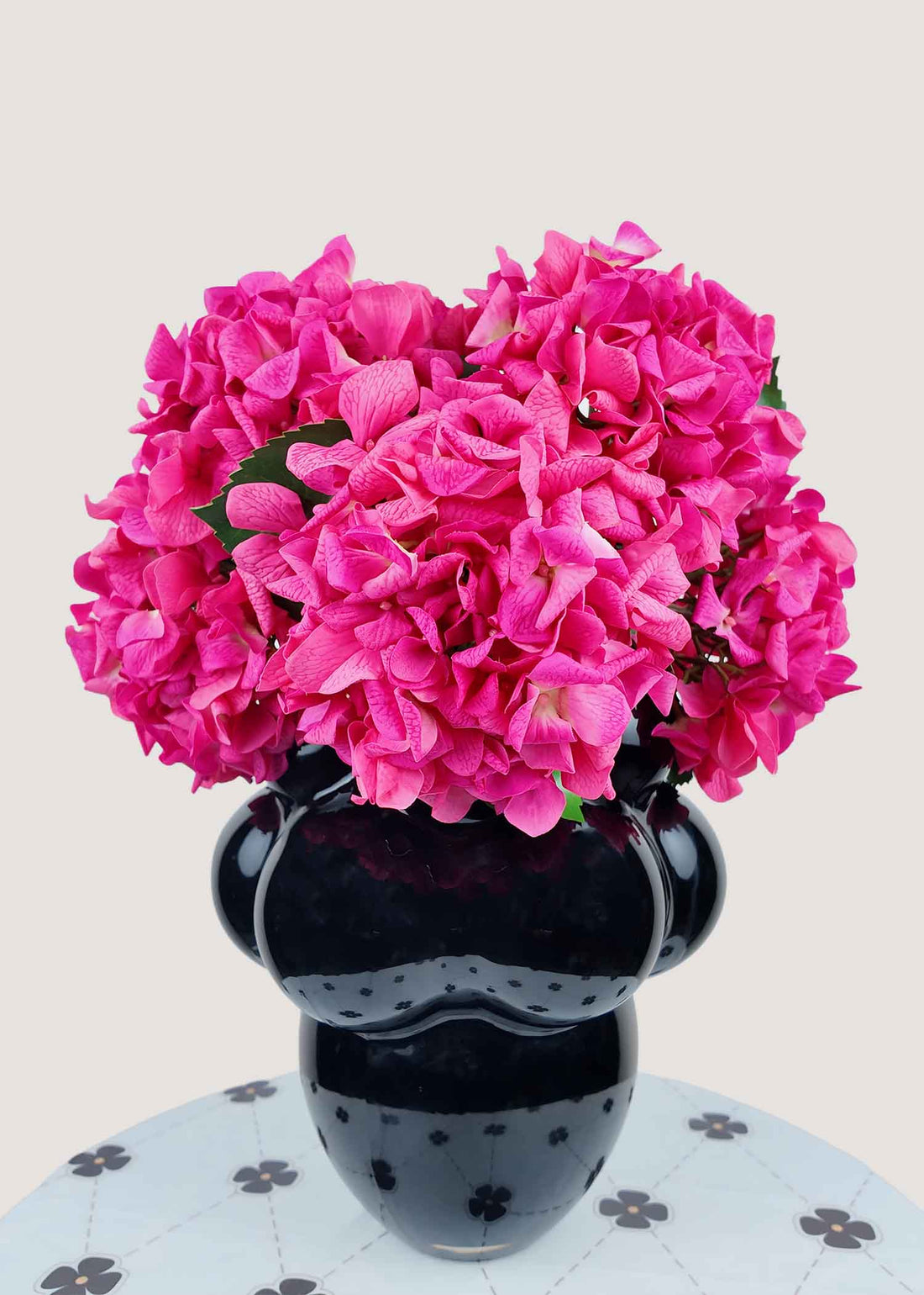 Vibrant hot pink artificial hydrangea bouquet in modern black vase