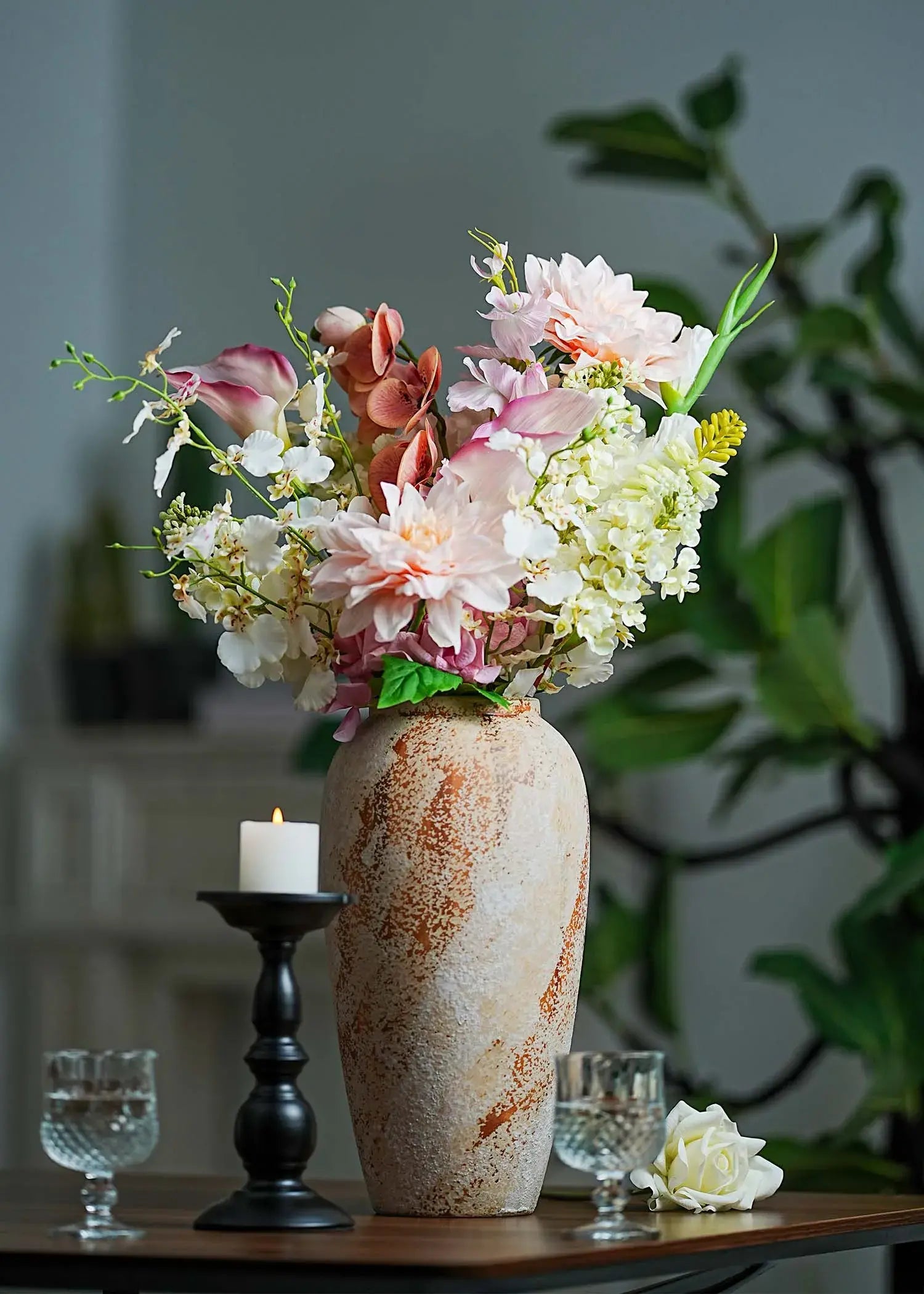 Peach blush artificial flower arrangement with orchids, dahlias, and calla lilies in a rustic vase styled with candle décor – Everblooma luxury faux flowers