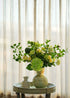 Real Touch green hydrangea and white rose faux floral arrangement in a ceramic vase on a round table with curtain backdrop — Everblooma home décor.